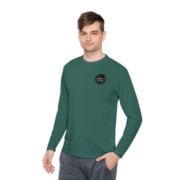 A person wearing a green Unisex Lightweight Long Sleeve Tee with a "Circle of Genius" logo and gray pants stands against a white background.