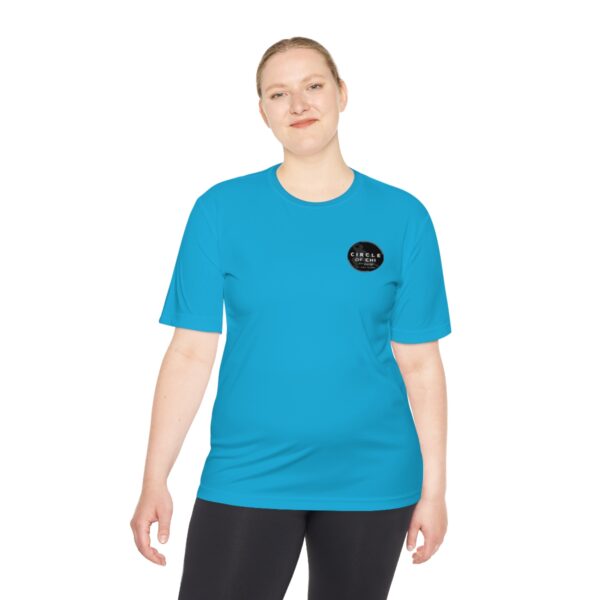 Person wearing a Circle of Chi Athletic Tee with a circular logo on the left chest and black leggings, standing in a relaxed pose.