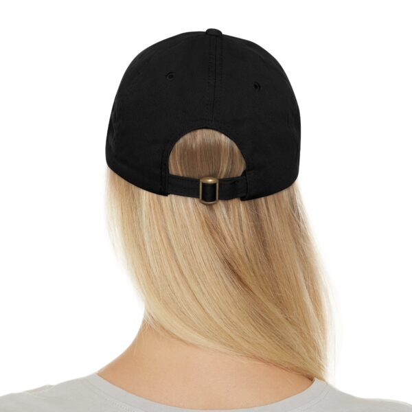 A person with long blonde hair is wearing a Circle of Chi Dad Hat with Leather Patch viewed from the back. The cap has an adjustable strap and an opening above the strap.