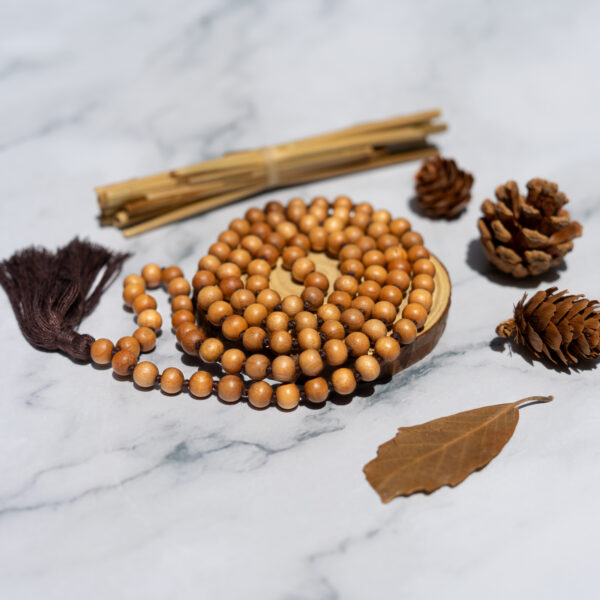 Wooden beaded necklace on marble surface.